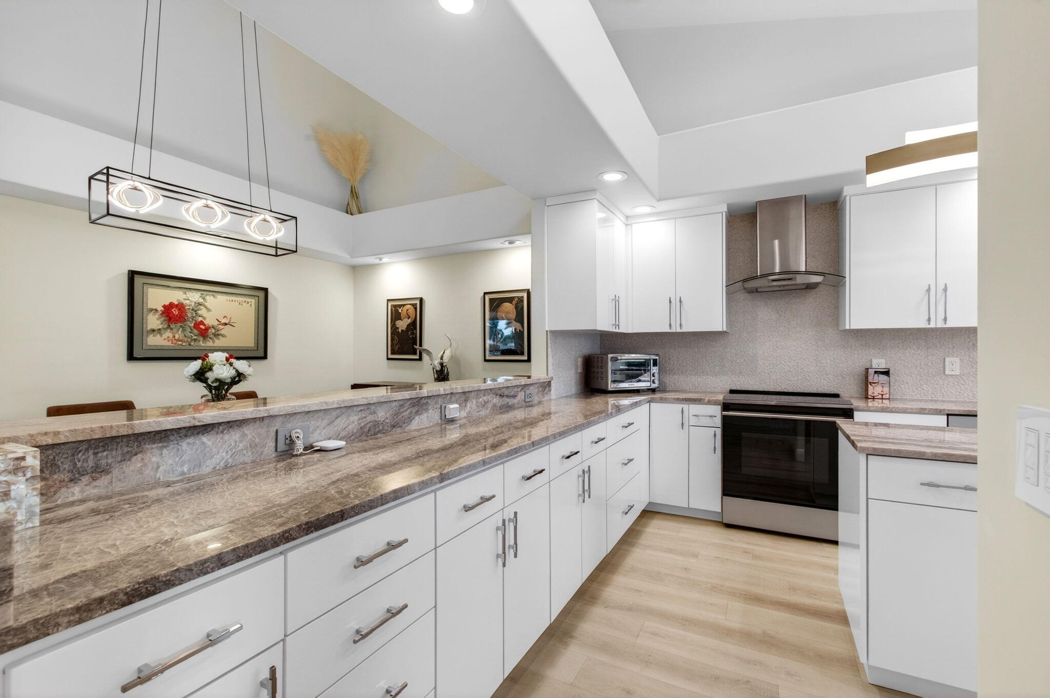 2530 Coco Plum Boulevard, Unit 1002 Boca Raton, FL 33496 - Photo 21 of 61 a large kitchen with granite countertop a sink and white cabinets