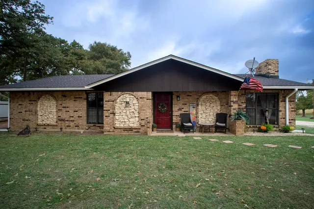 a view of a house with a yard and sitting area