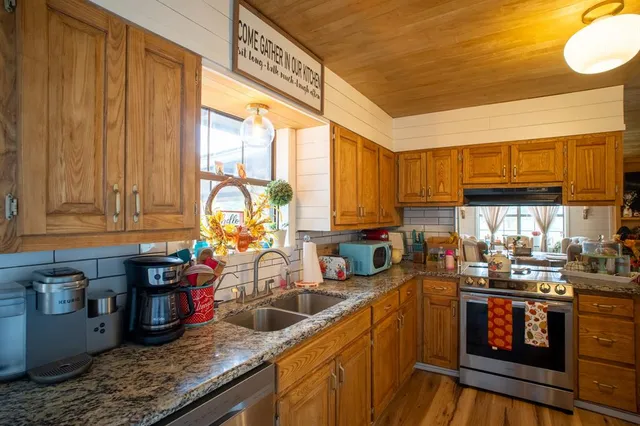 a kitchen with sink a window and cabinets