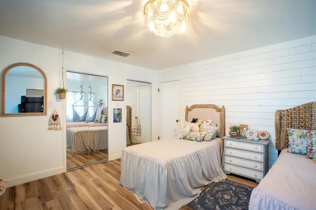 a bedroom with two beds and a chandelier