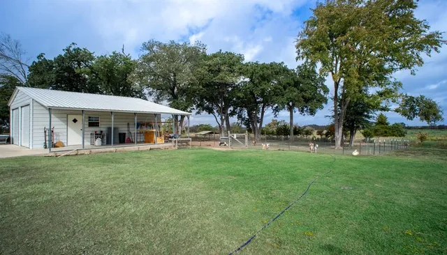 a backyard of a house with table and chairs