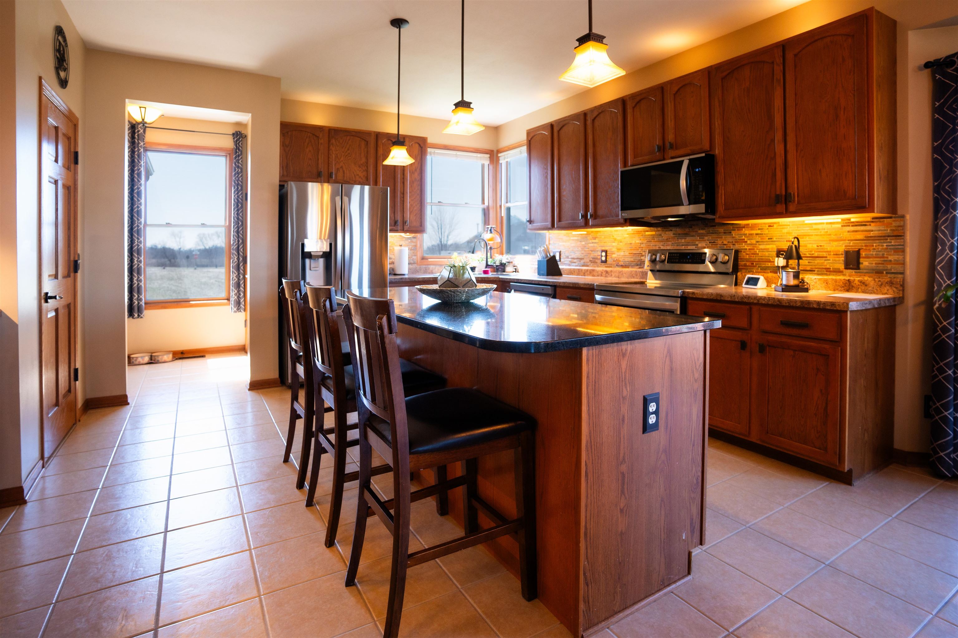 314 Brocket Trail Belvidere, IL 61008 - Photo 15 of 46 a kitchen with stainless steel appliances granite countertop a stove top oven a sink dishwasher a dining table and chairs with wooden floor