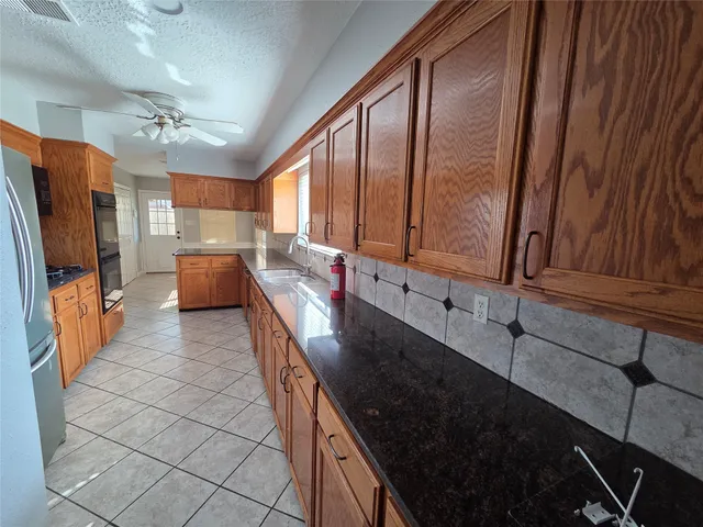 a kitchen with stainless steel appliances granite countertop a refrigerator and a sink