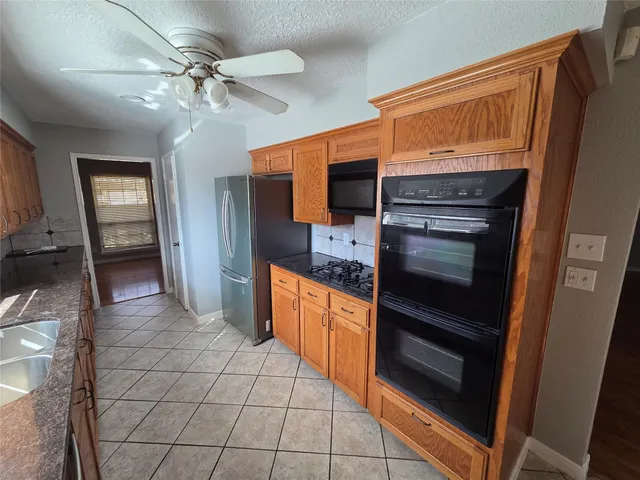 a kitchen with stainless steel appliances granite countertop a sink stove and cabinets