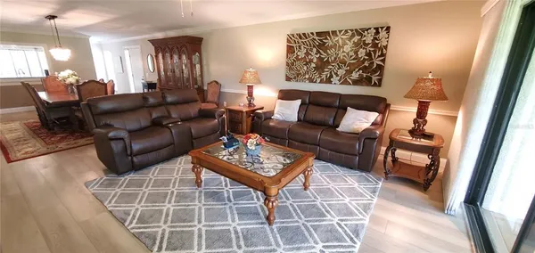 a living room with furniture a dining table and a large window