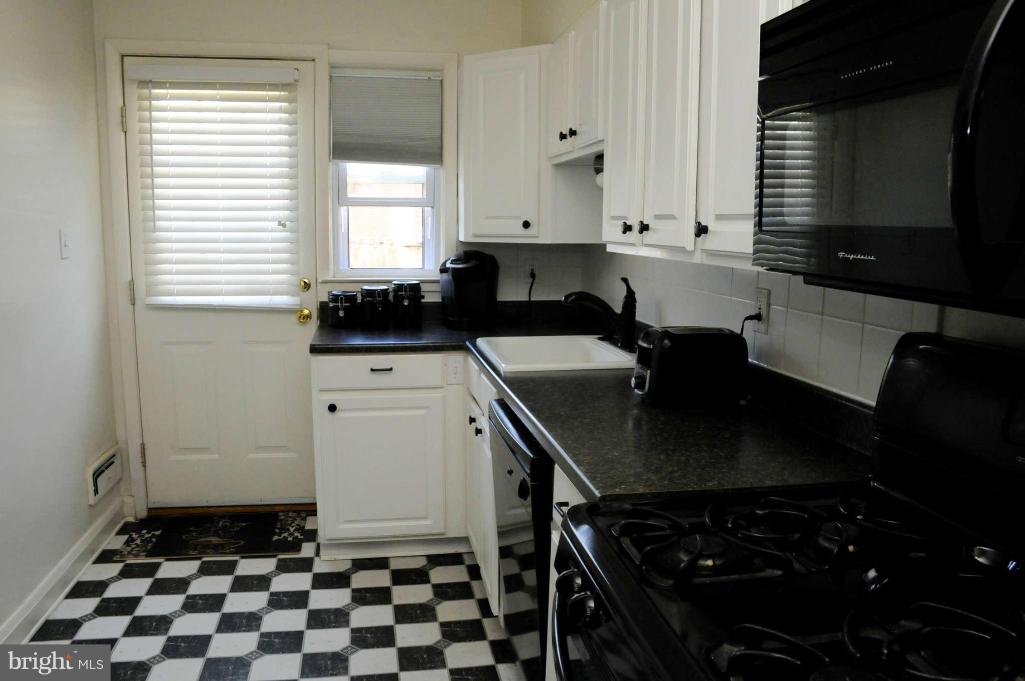 516 Queensgate Road Baltimore, MD 21229 - Photo 15 of 27 a kitchen with a sink a stove and cabinets