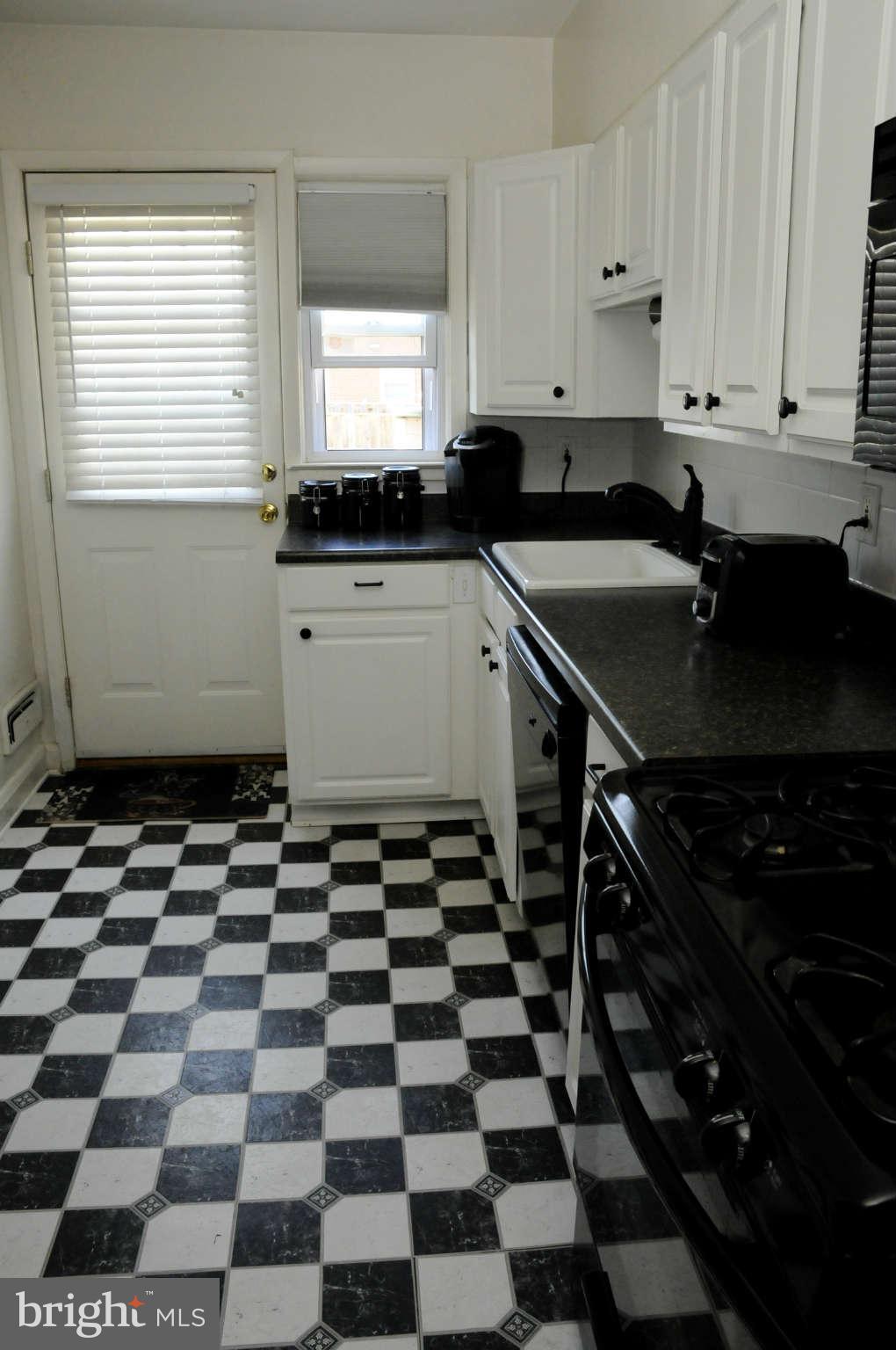 516 Queensgate Road Baltimore, MD 21229 - Photo 16 of 27 a kitchen with a sink a stove and a window