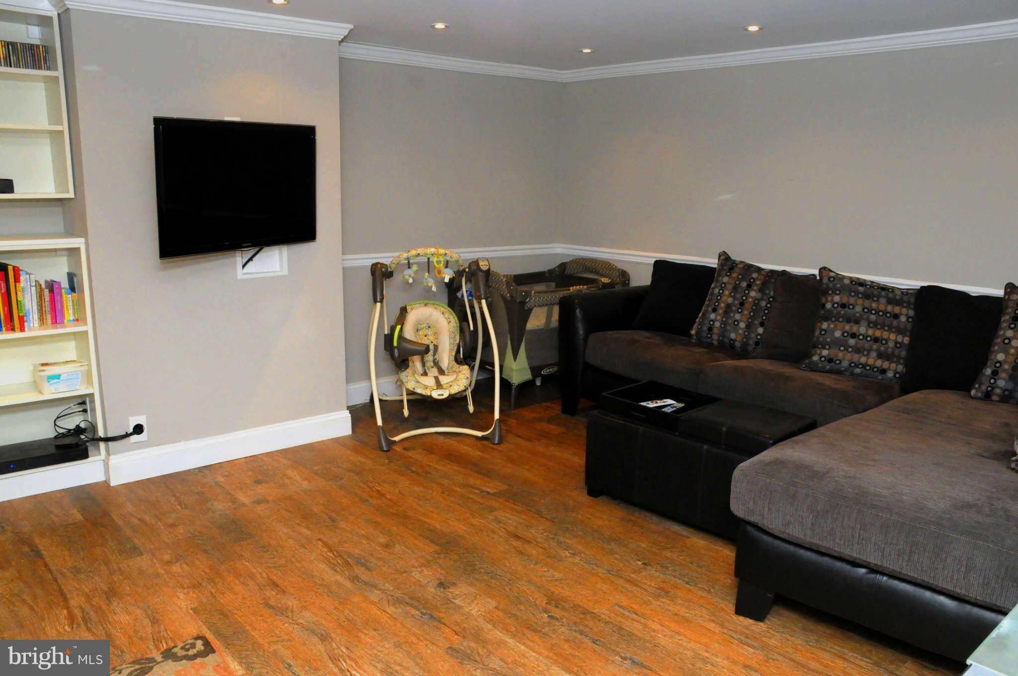 516 Queensgate Road Baltimore, MD 21229 - Photo 22 of 27 a living room with furniture and a flat screen tv