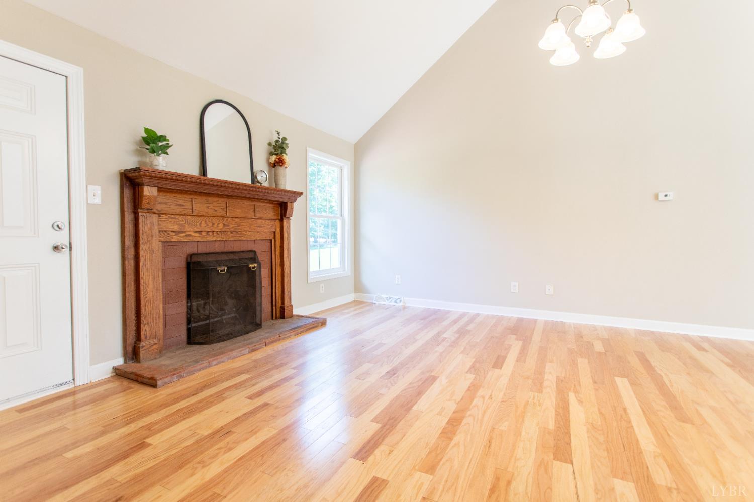 549 Thrashers Creek Road Amherst, VA 24521 - Photo 14 of 66 a view of a livingroom with wooden floor and a fireplace