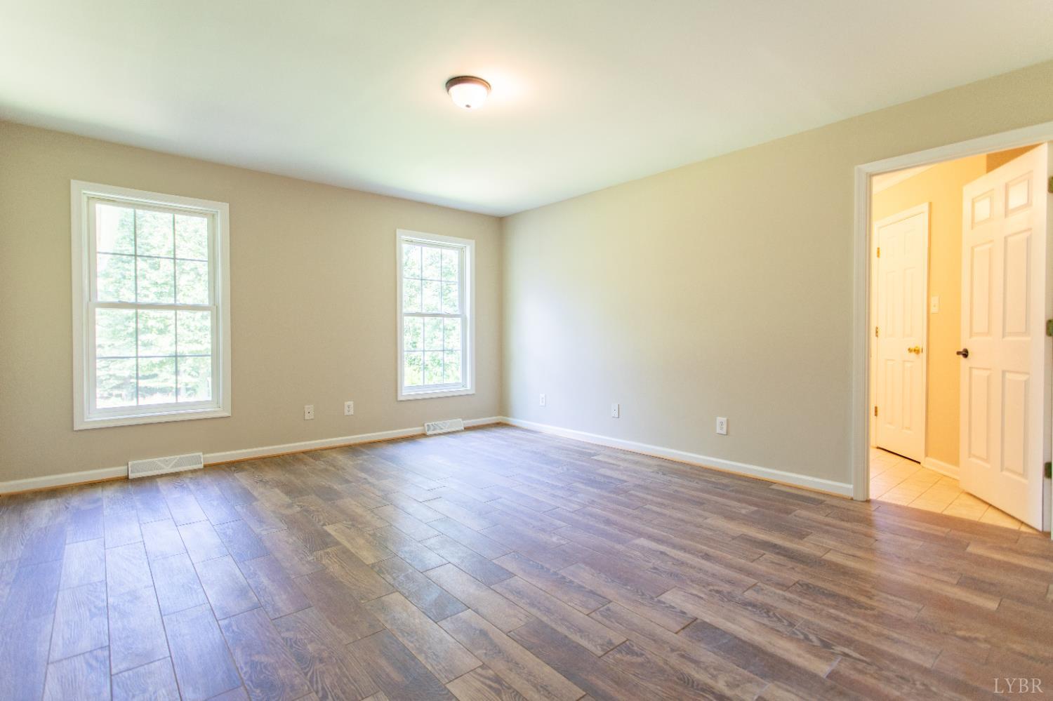549 Thrashers Creek Road Amherst, VA 24521 - Photo 26 of 66 an empty room with wooden floor and windows