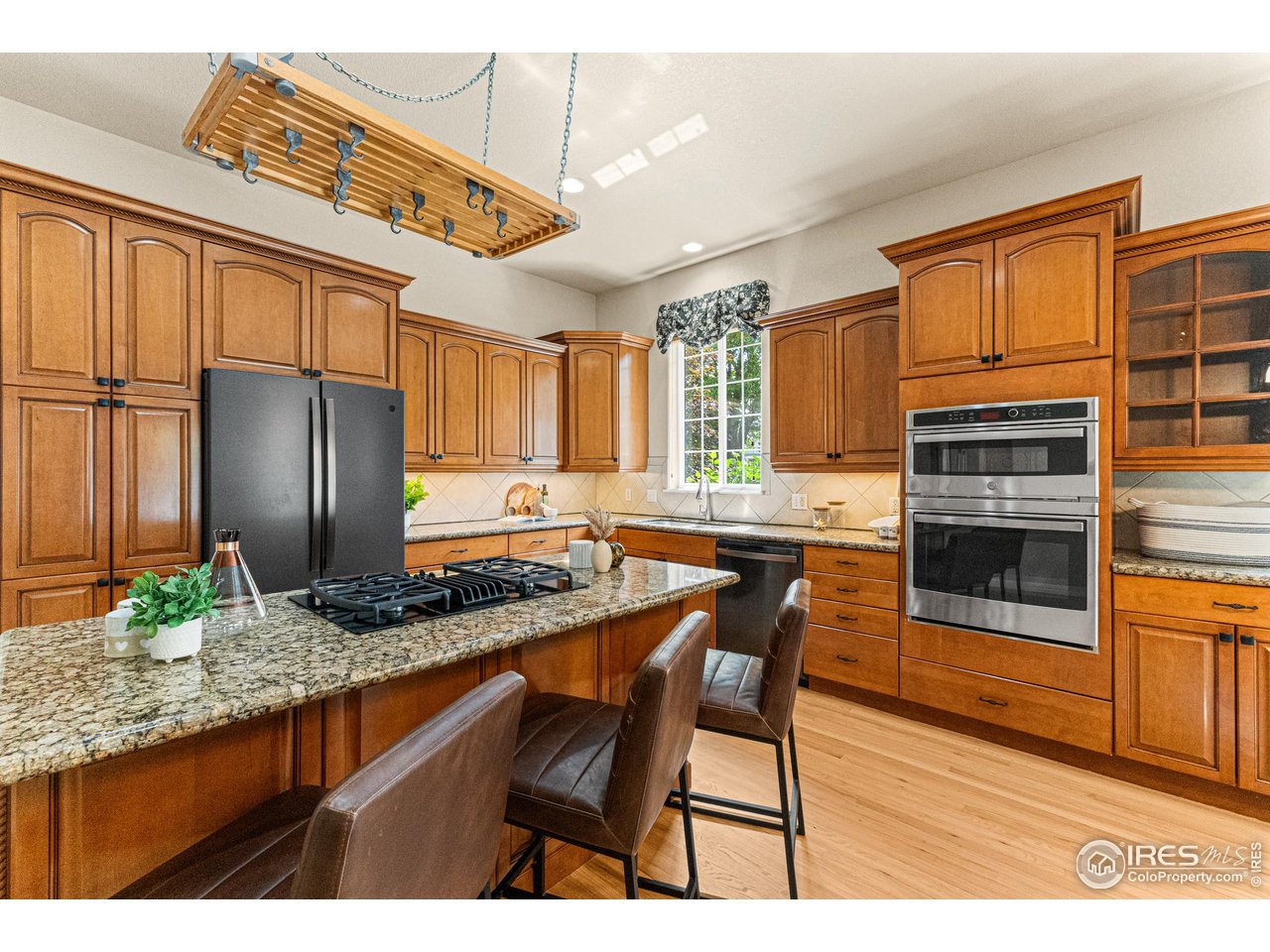 6495 Eagle Shadow Avenue Brighton, CO 80602 - Photo 10 of 40 a kitchen with stainless steel appliances granite countertop a stove a refrigerator and a microwave