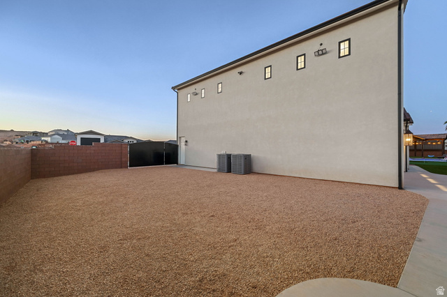 4871 South Homestead Way Washington, UT 84780 - Photo 119 of 151 Property exterior at dusk with a fenced backyard and stucco siding
