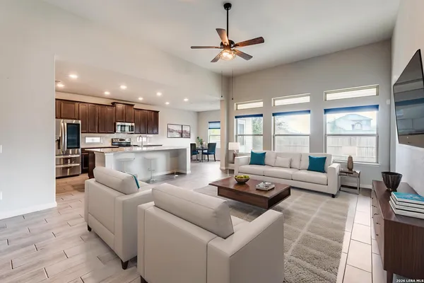 a living room with furniture and a large window with kitchen view