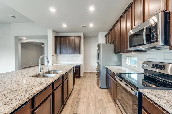 a kitchen with kitchen island granite countertop wooden cabinets a sink and dishwasher