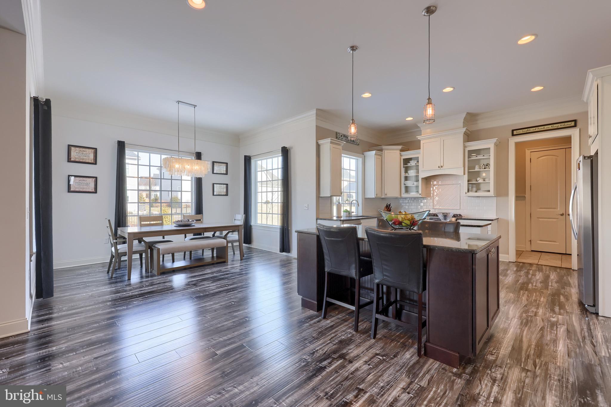698 Warminster Lane Lititz, PA 17543 - Photo 13 of 49 a open kitchen with stainless steel appliances granite countertop a stove a refrigerator a sink a dining table and chairs with wooden floor