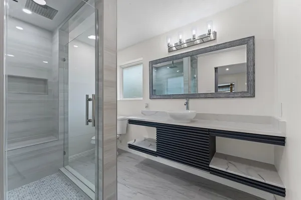 a bathroom with a sink a light fixture and a mirror