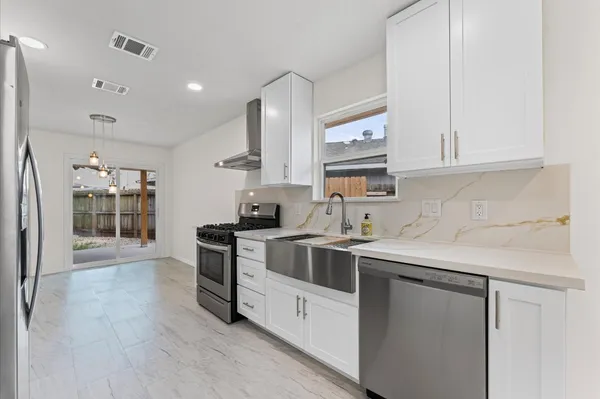 a kitchen with stainless steel appliances granite countertop a sink stove and refrigerator