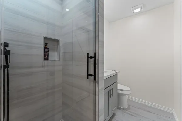 a bathroom with a granite countertop toilet and a shower
