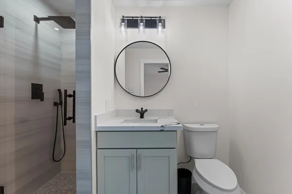a bathroom with a sink a toilet and a mirror