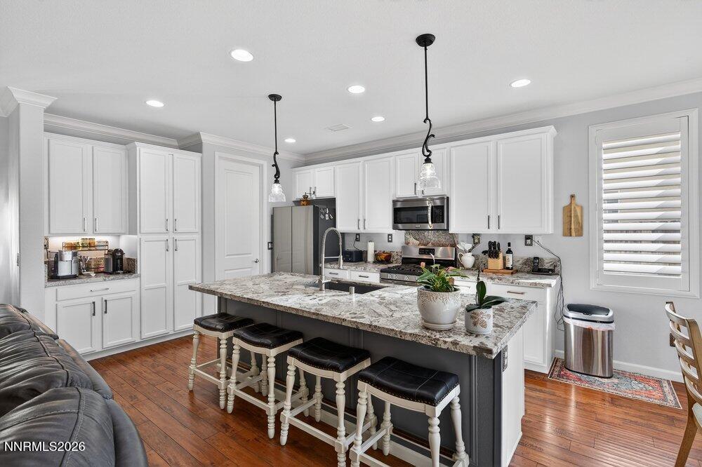 1473 Hogadon Way Reno, NV 89523 - Photo 13 of 40 a kitchen with stainless steel appliances granite countertop a stove top oven a refrigerator a sink and kitchen island with wooden floor