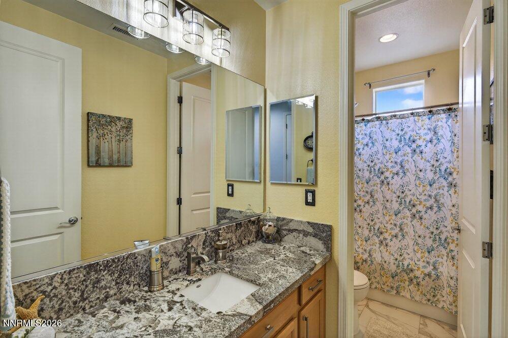 1473 Hogadon Way Reno, NV 89523 - Photo 22 of 40 a bathroom with a granite countertop sink a mirror and a shower