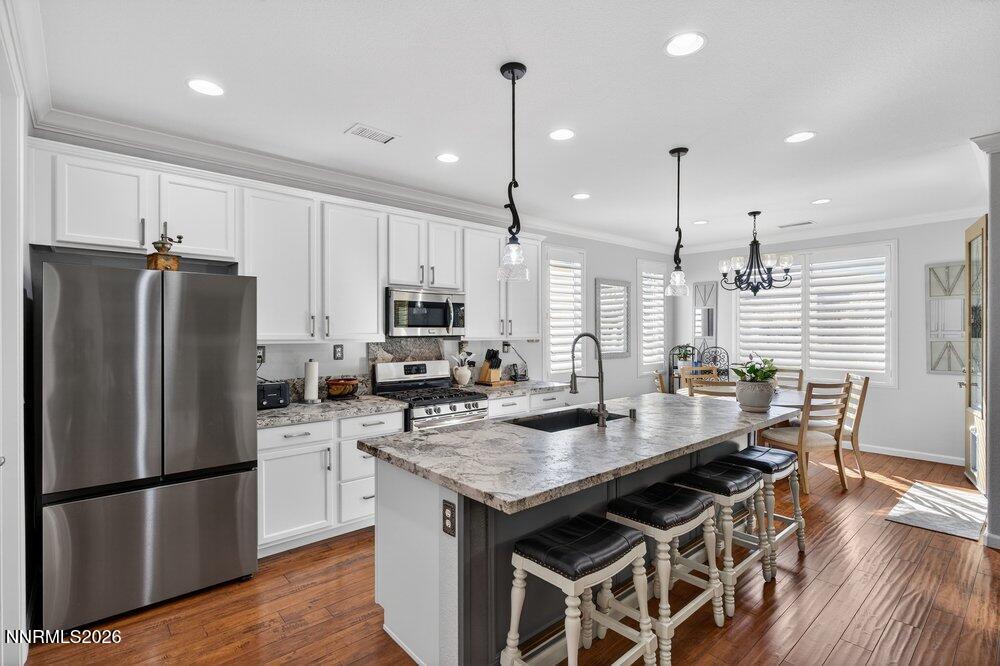 1473 Hogadon Way Reno, NV 89523 - Photo 8 of 40 a kitchen with stainless steel appliances granite countertop a refrigerator a stove a sink dishwasher a refrigerator and white cabinets with wooden floor