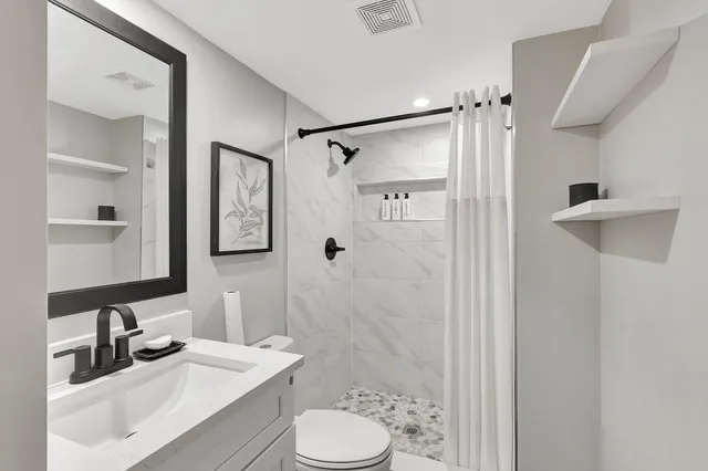 a bathroom with a sink toilet tub and shower