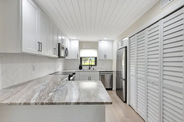 a kitchen with sink refrigerator and microwave