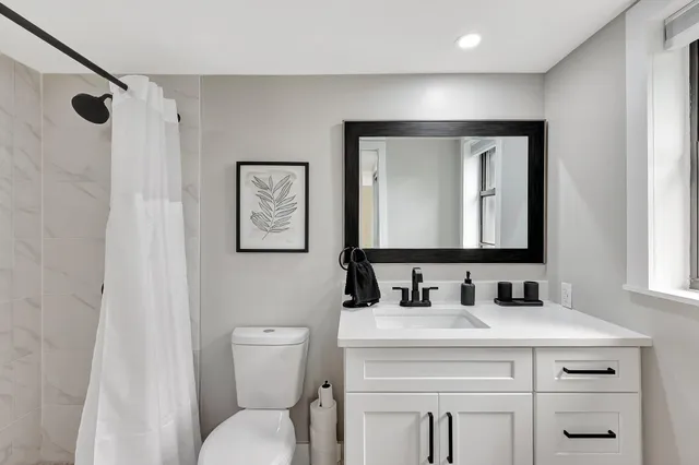 a bathroom with a toilet sink and mirror