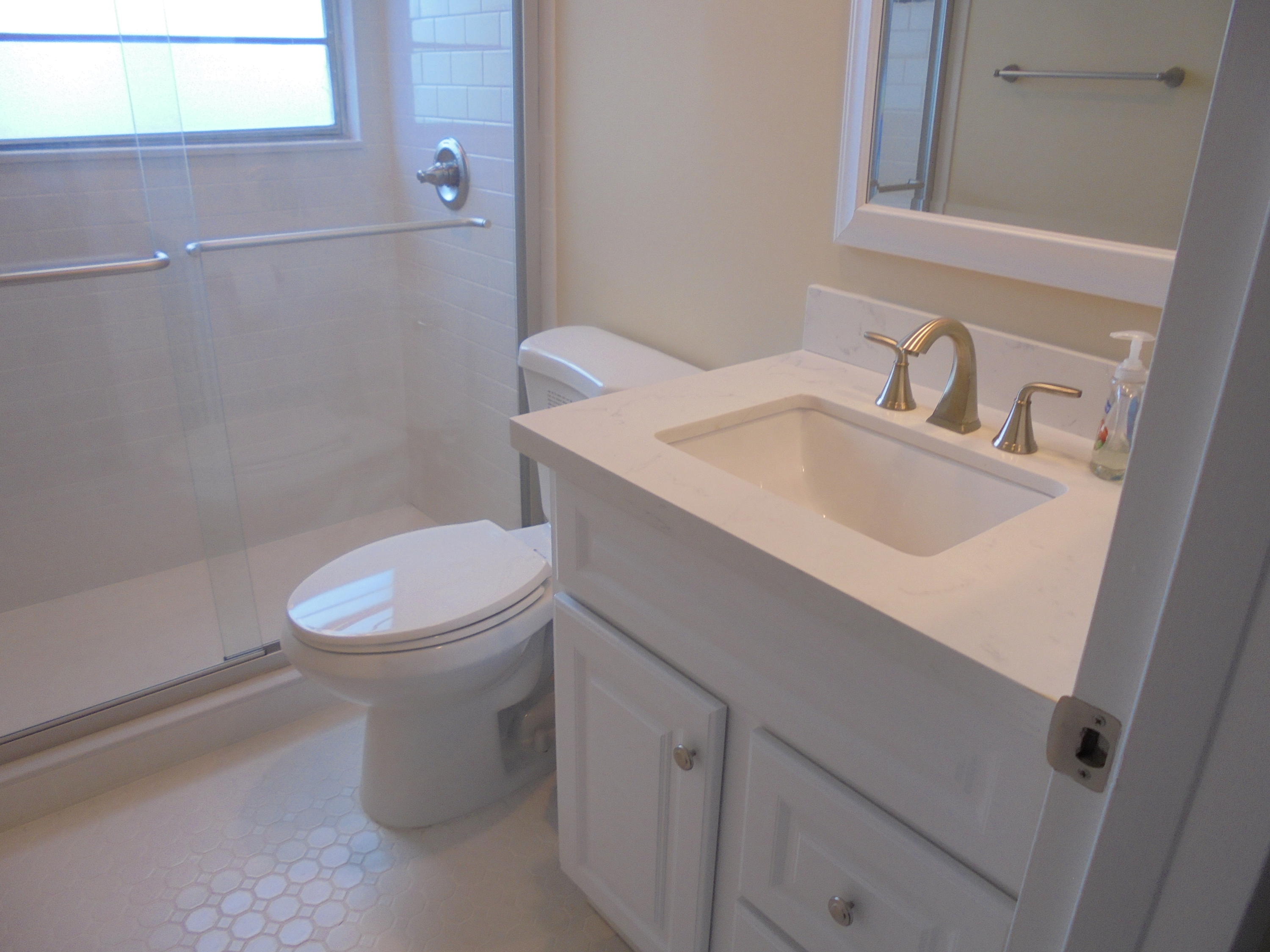 98 Fanshaw C Boca Raton, FL 33434 - Photo 6 of 11 a white toilet sitting next to a bathroom sink