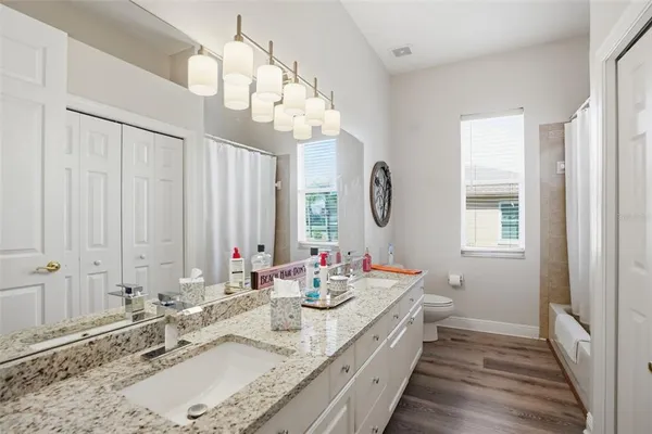 a bathroom with double vanity sinks a vanity two mirror and a window