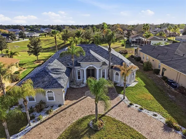 an aerial view of a house with a garden and lake view