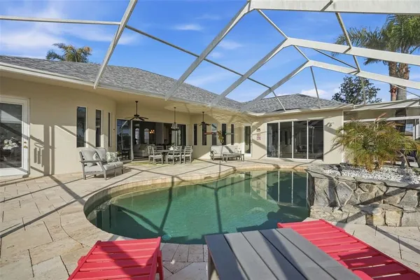 a view of a backyard with swimming pool table and chairs