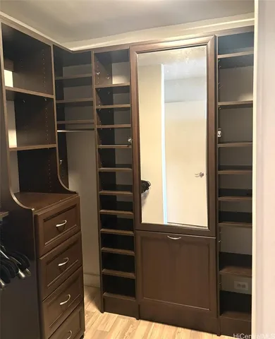 a view of closet with wooden floor