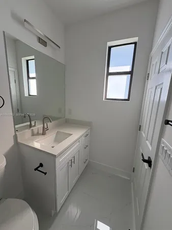 a bathroom with a sink toilet and mirror