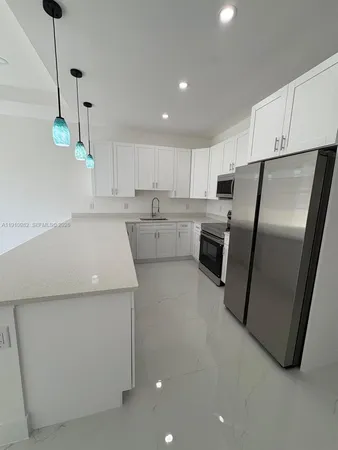 a kitchen filled with white cabinets and stainless steel appliances