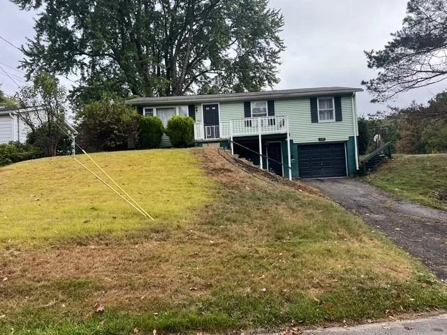 a view of a house with backyard and trees