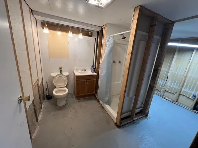 a bathroom with a granite countertop sink toilet and shower