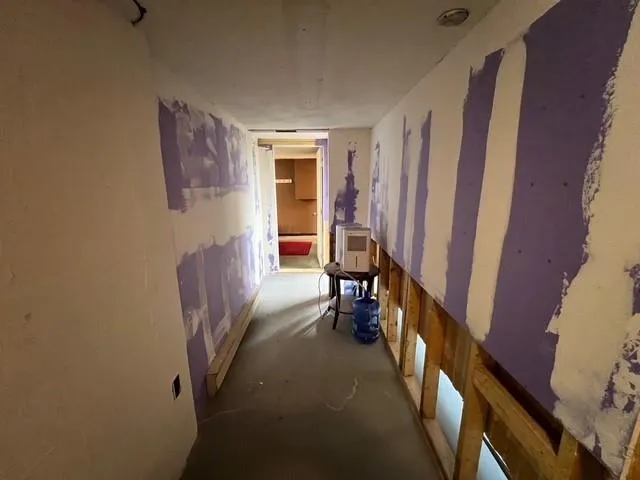 a view of a hallway with furniture and a window
