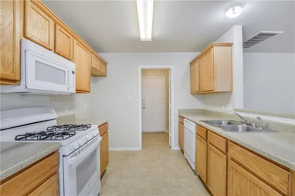 a kitchen with a sink stove top oven and cabinets