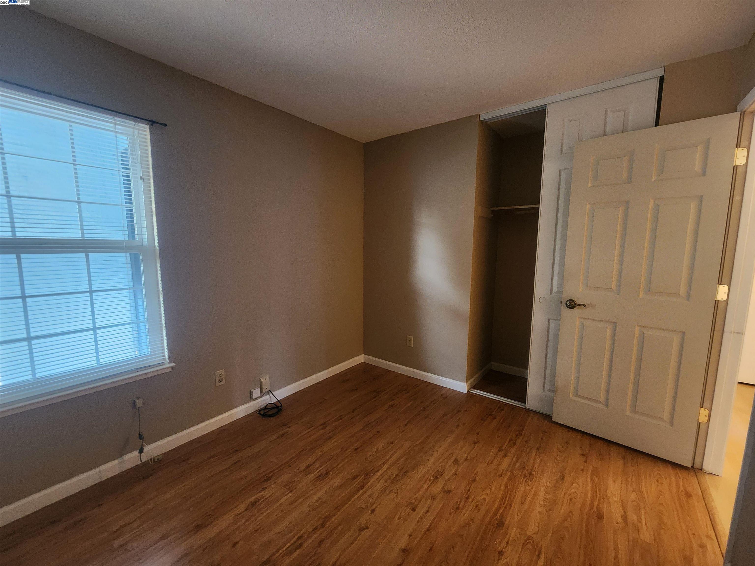 1733 Carnation Circle Livermore, CA 94551 - Photo 12 of 27 an empty room with wooden floor cabinet and windows