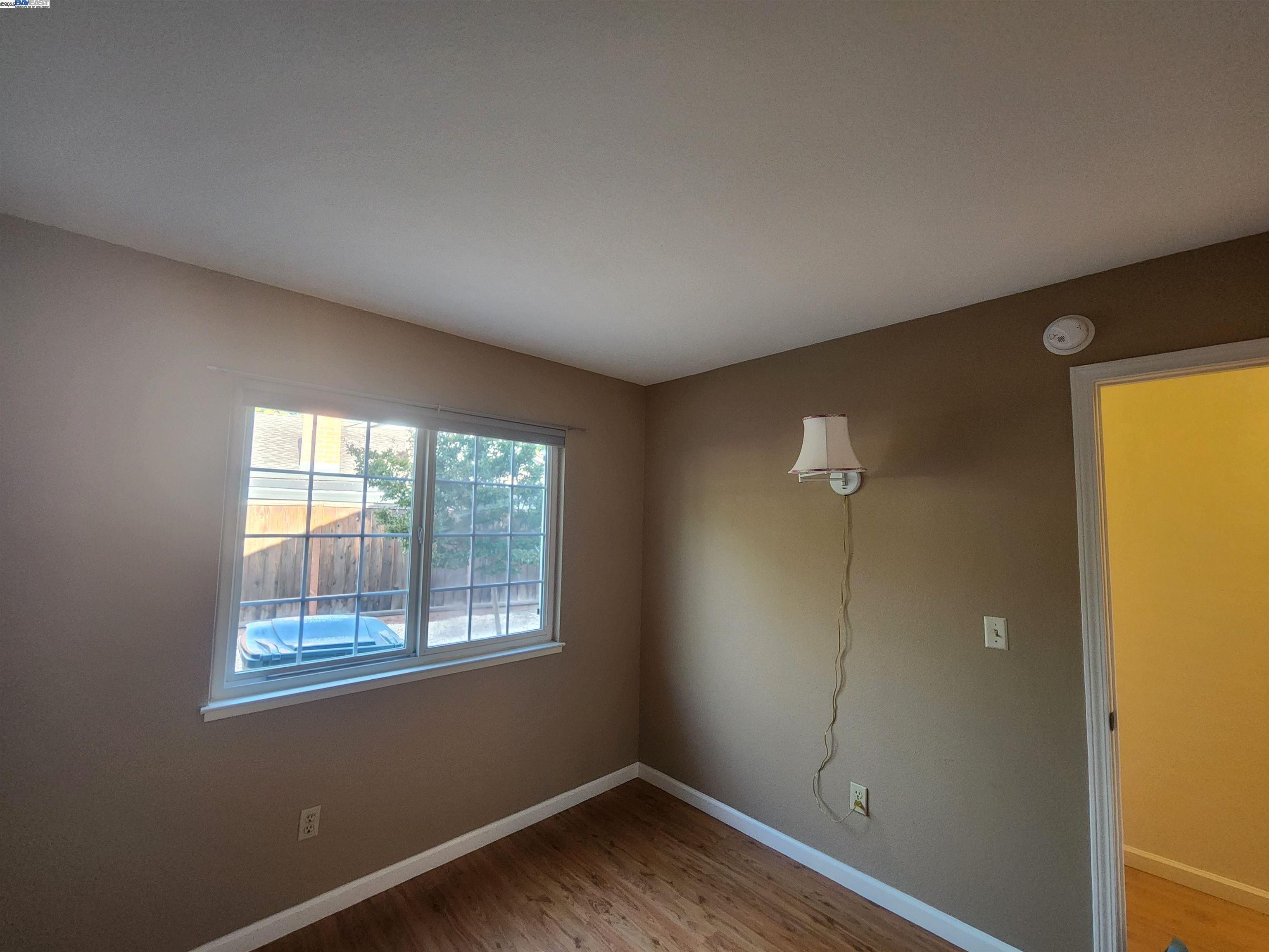 1733 Carnation Circle Livermore, CA 94551 - Photo 13 of 27 an empty room with wooden floor and windows