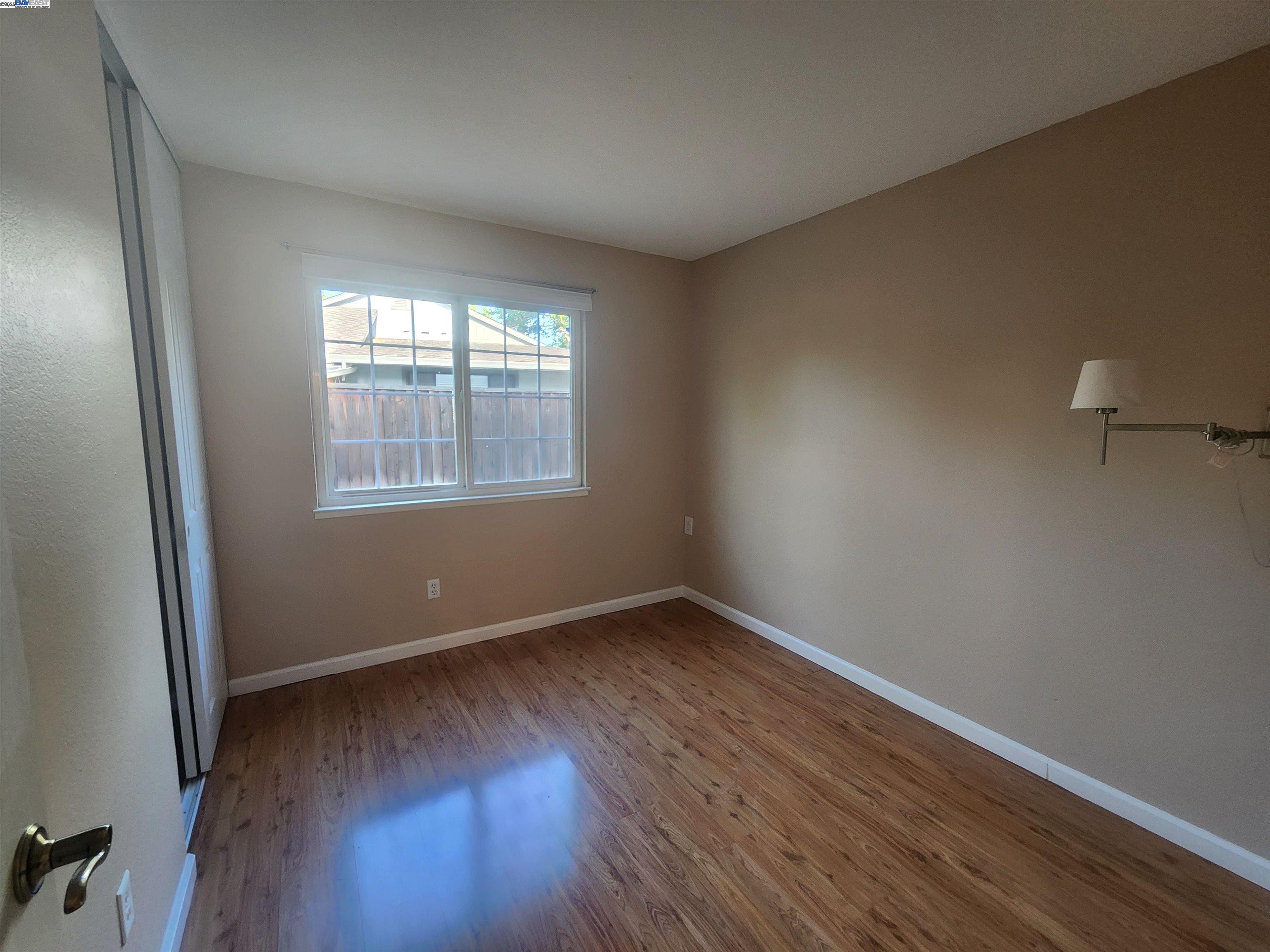 1733 Carnation Circle Livermore, CA 94551 - Photo 17 of 27 an empty room with wooden floor and windows