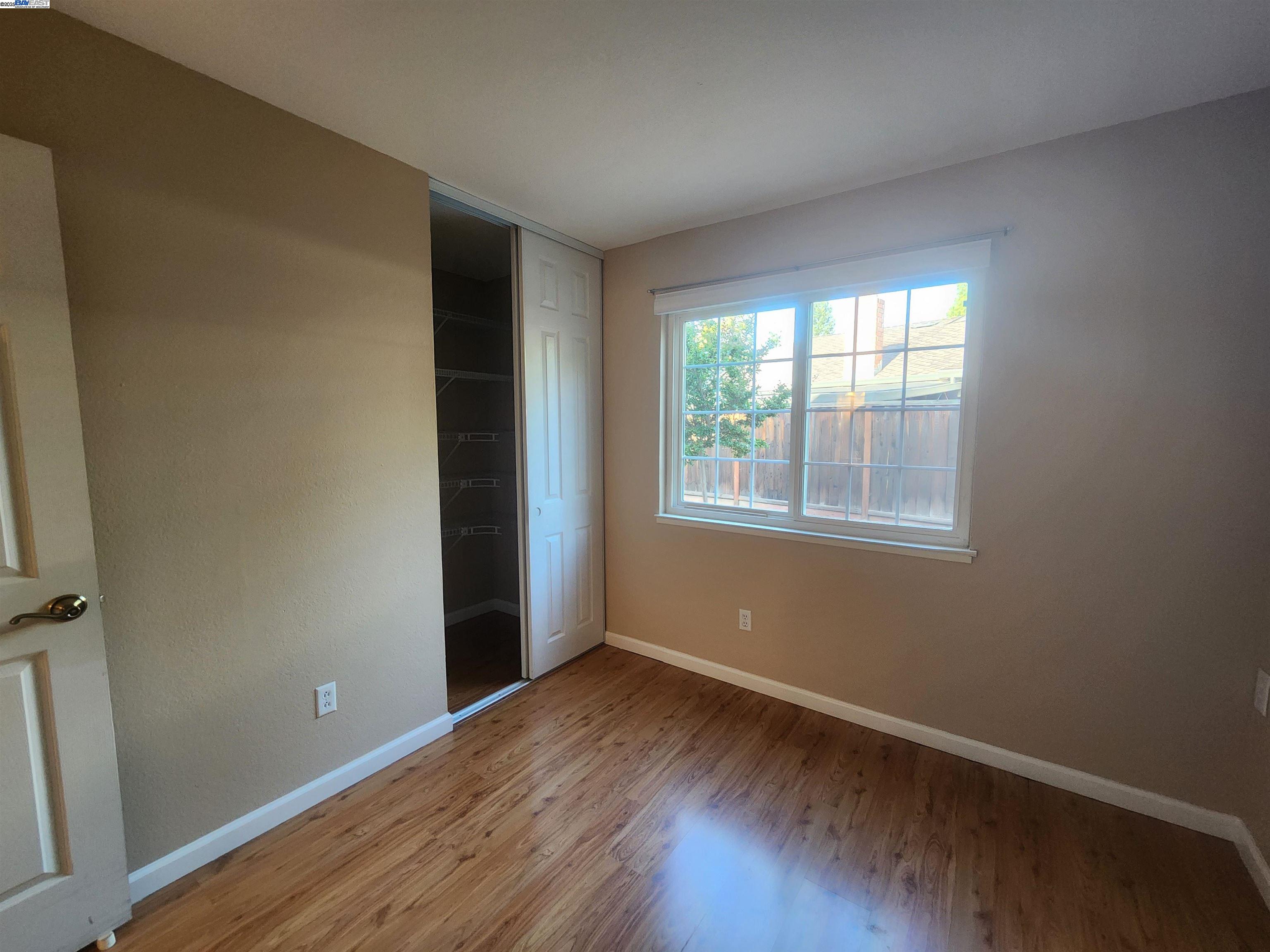1733 Carnation Circle Livermore, CA 94551 - Photo 18 of 27 an empty room with wooden floor and windows
