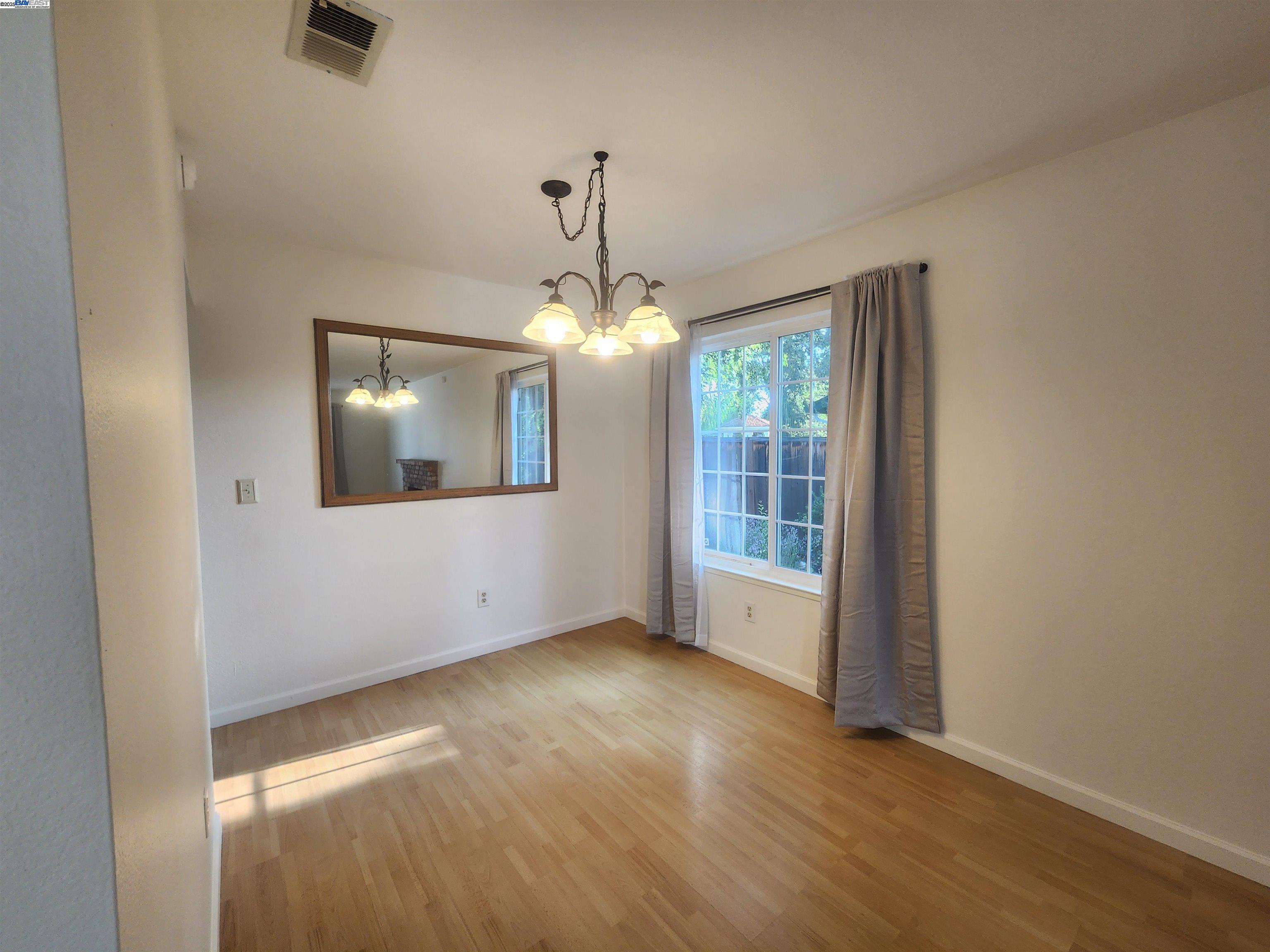 1733 Carnation Circle Livermore, CA 94551 - Photo 5 of 27 an empty room with wooden floor fan and windows