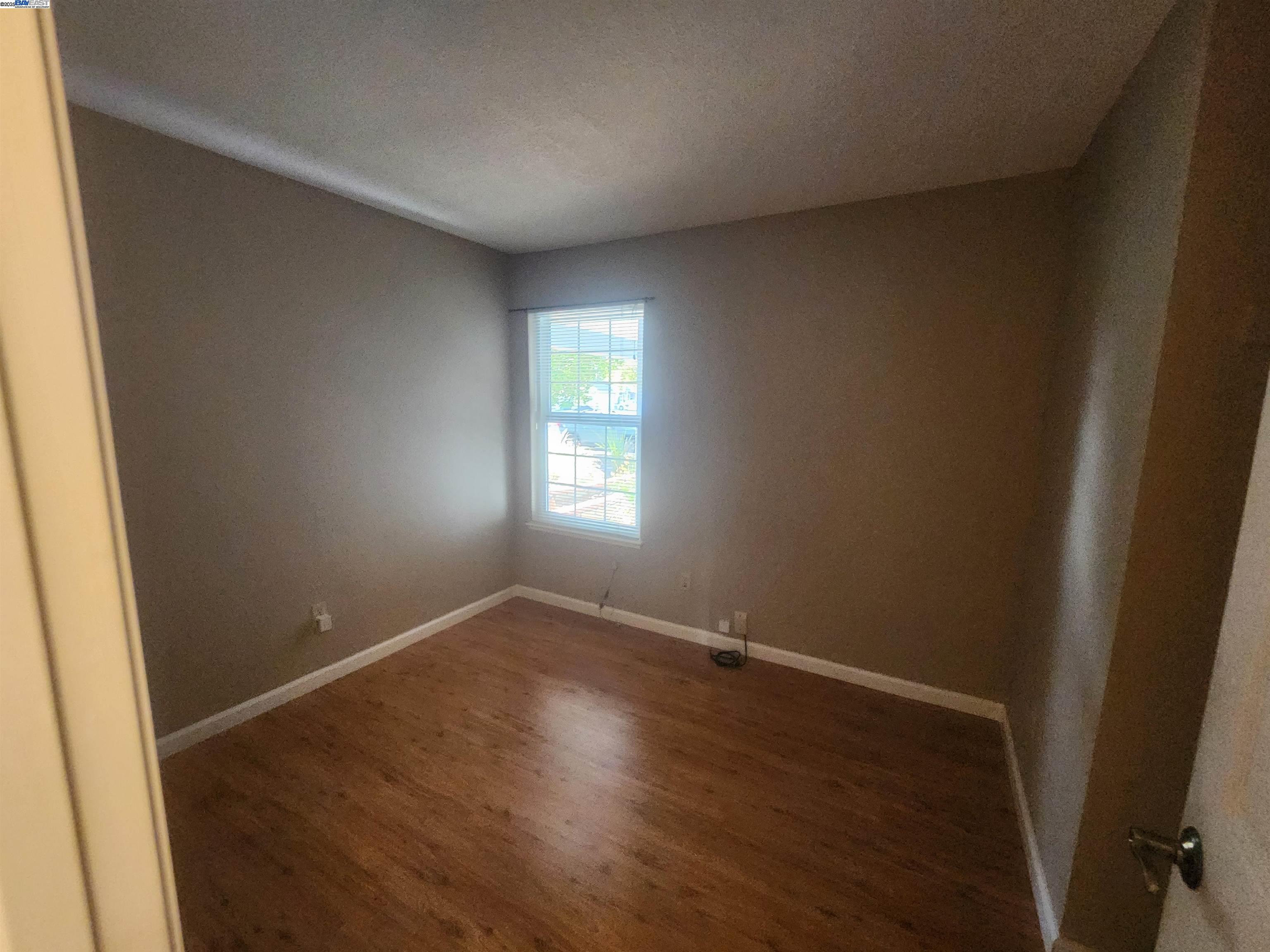 1733 Carnation Circle Livermore, CA 94551 - Photo 9 of 27 an empty room with wooden floor and windows