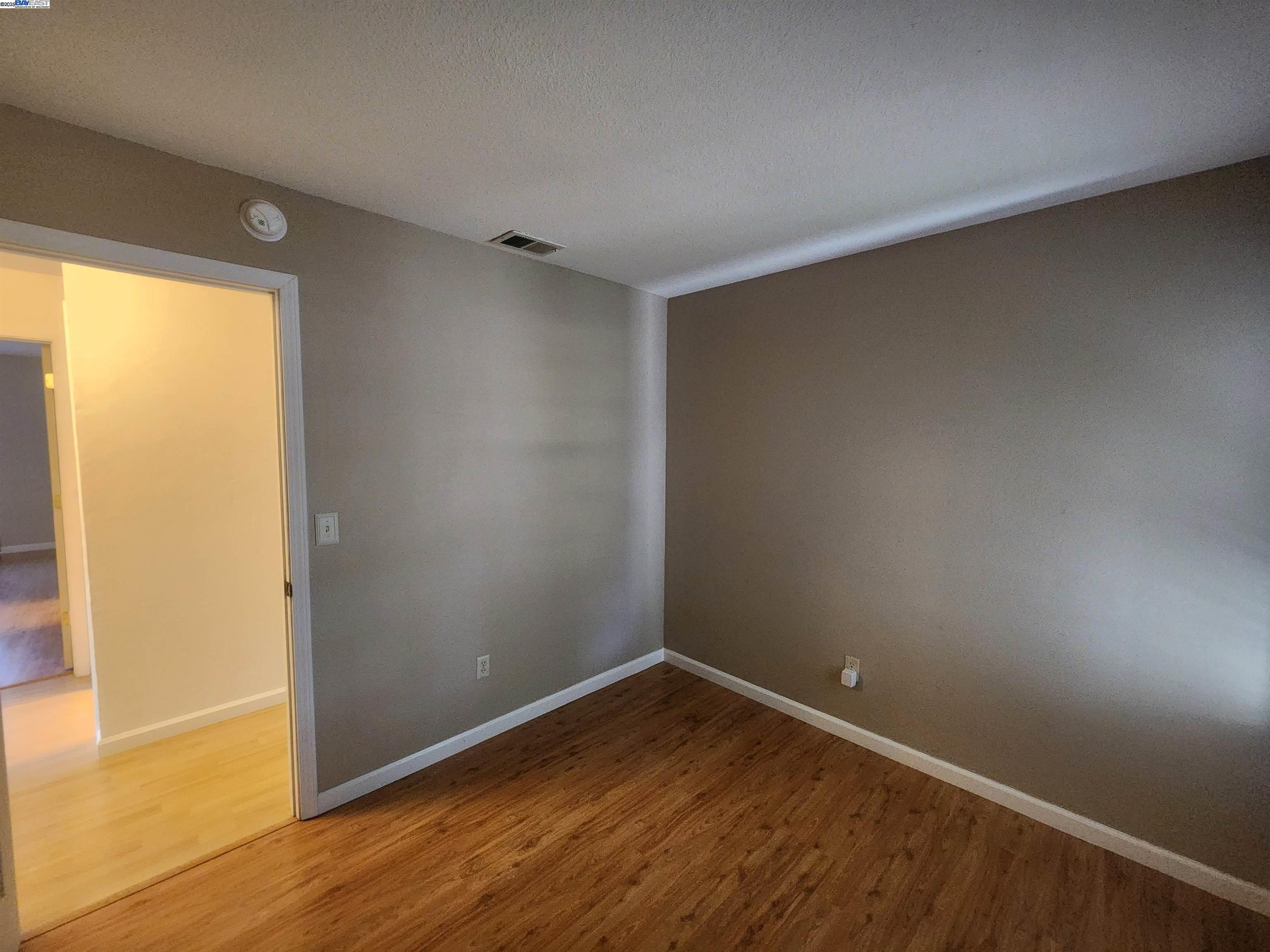 1733 Carnation Circle Livermore, CA 94551 - Photo 10 of 27 a view of an empty room with wooden floor and a window