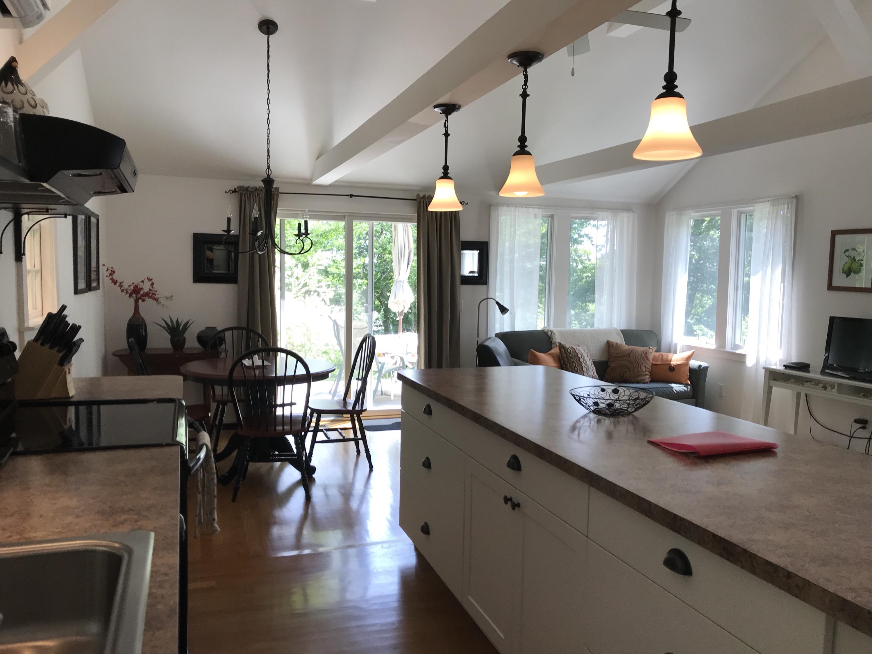 41 Castle Road Truro, MA 02666 - Photo 9 of 16 a view of a dining room and livingroom with furniture wooden floor a chandelier