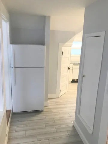 a view of a refrigerator in kitchen and wooden floor
