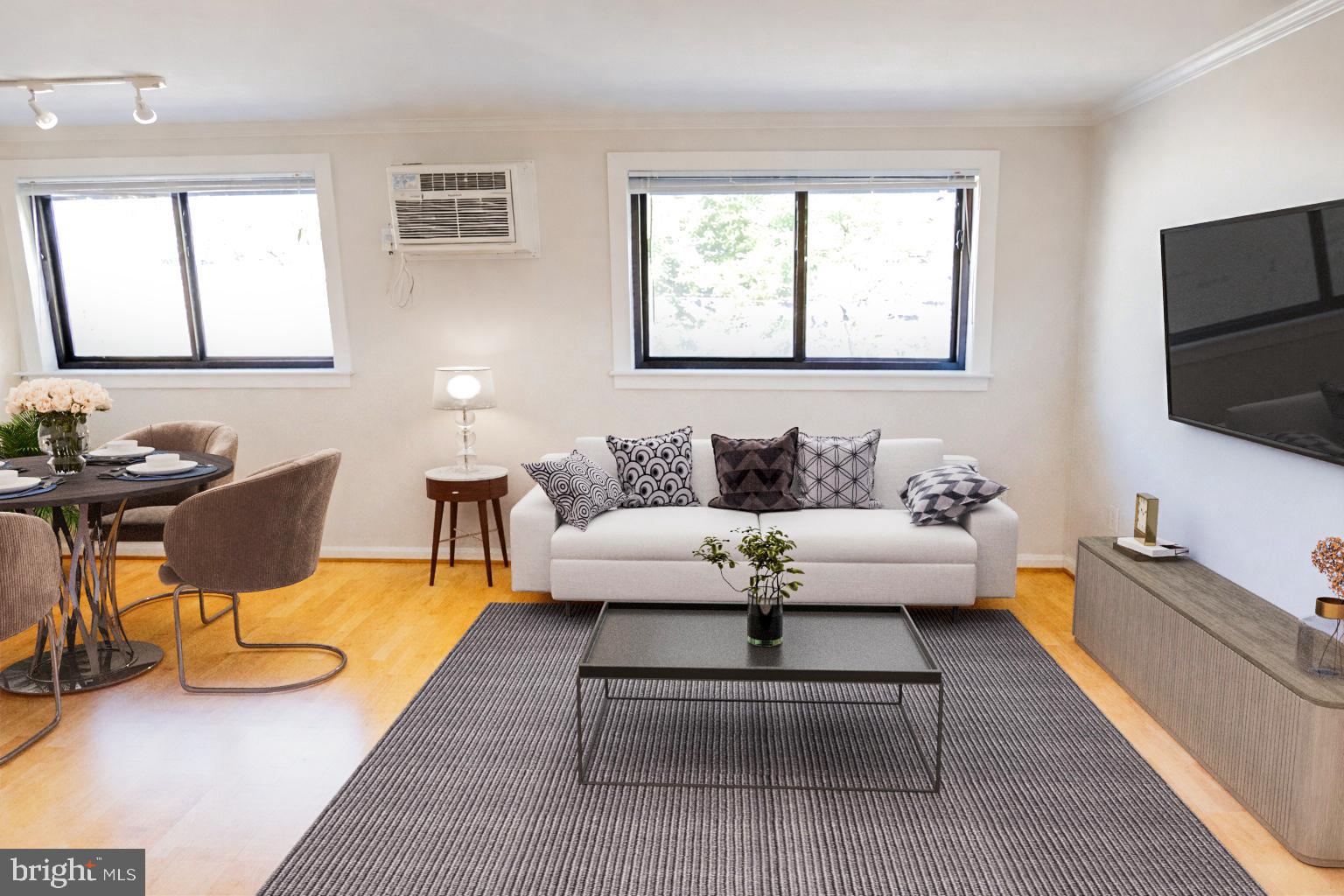 a living room with furniture a flat screen tv and a window